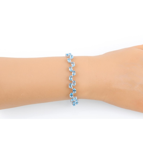 238 - A BLUE TOPAZ AND DIAMOND BRACELET, the oval topaz stone set between diamonds