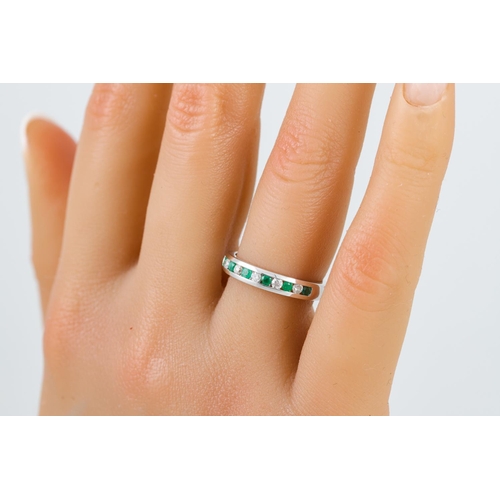 239 - A DIAMOND AND EMERALD HALF ETERNITY RING, channel set.  Estimated: weight of diamonds: 0.20 ct