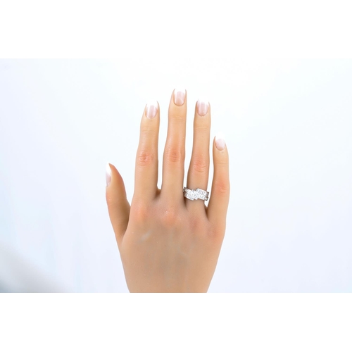 244 - A DIAMOND SET RING, the princess cut diamond to a cross-over princess and baguette cut mount, platin... 