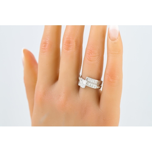 244 - A DIAMOND SET RING, the princess cut diamond to a cross-over princess and baguette cut mount, platin... 