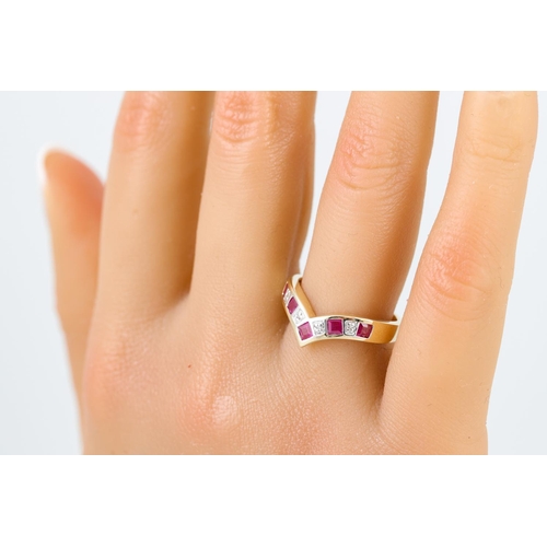 267 - A DIAMOND AND RUBY HALF ETERNITY RING, wishbone shaped, mounted in 9ct yellow gold, size N