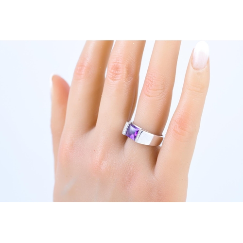 274 - AN AMETHYST DRESS RING, the cabochon stone set to diamond detail, mounted in 18ct white gold, size L... 