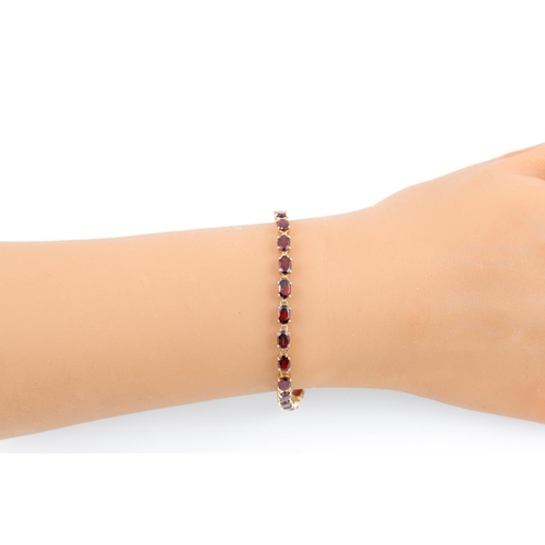 276 - A GARNET SET BRACELET, the oval stones, mounted in 14ct yellow gold