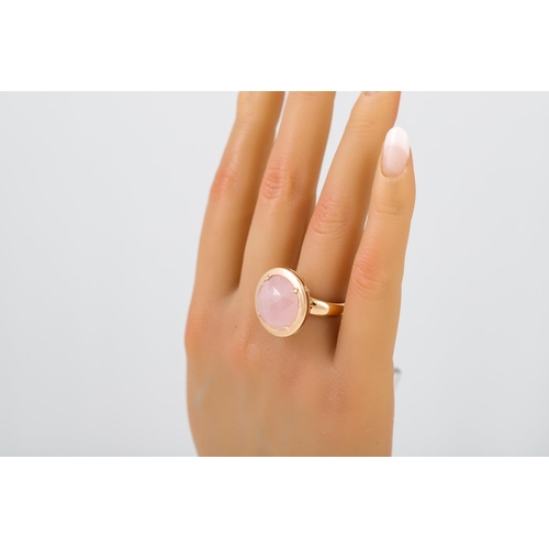 288 - A ROSE QUARTZ RING, the circular stone mounted in 18ct yellow gold, size L - M