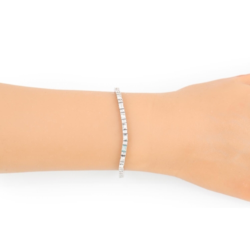 328 - A DIAMOND LINE BRACELET, set with brilliant cut diamonds and baguette cut diamonds, mounted in white... 