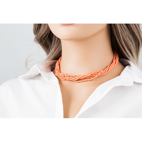 367 - A CORAL BEADED NECKLACE, comprising seven twisted strands, to an 18ct gold bow clasp