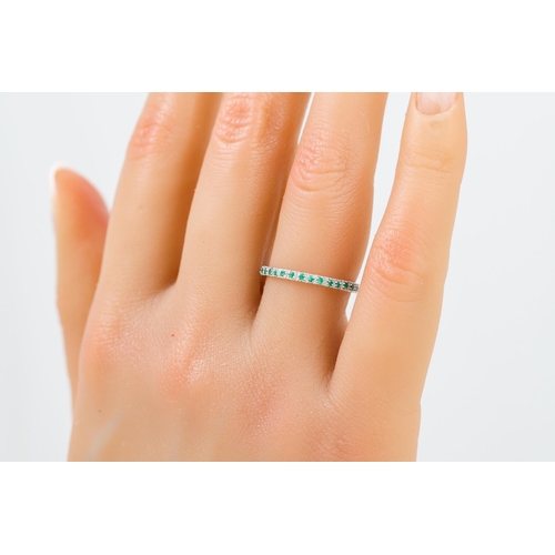 395 - AN EMERALD HALF ETERNITY RING, the circular stones mounted in 18ct white gold. Estimated: weight of ... 