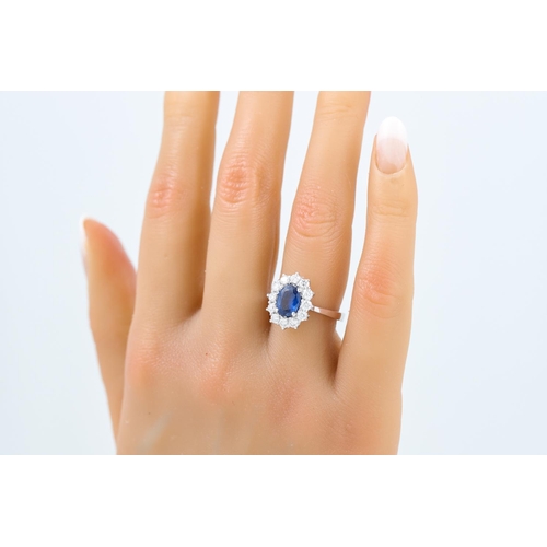 433 - A DIAMOND AND SAPPHIRE CLUSTER RING, the oval sapphire to a brilliant cut diamond surround, mounted ... 