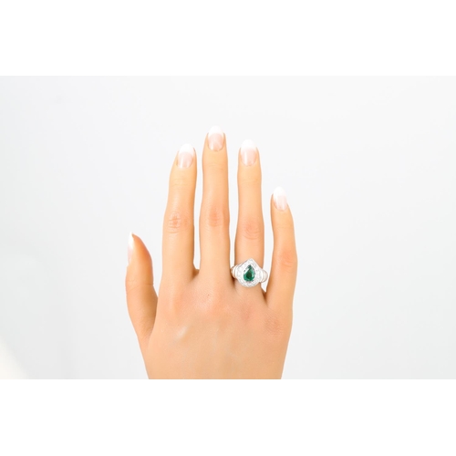 447 - AN EMERALD AND DIAMOND CLUSTER RING, the pear shaped to a brilliant cut diamond surround, to an 18ct... 