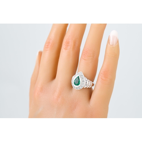 447 - AN EMERALD AND DIAMOND CLUSTER RING, the pear shaped to a brilliant cut diamond surround, to an 18ct... 