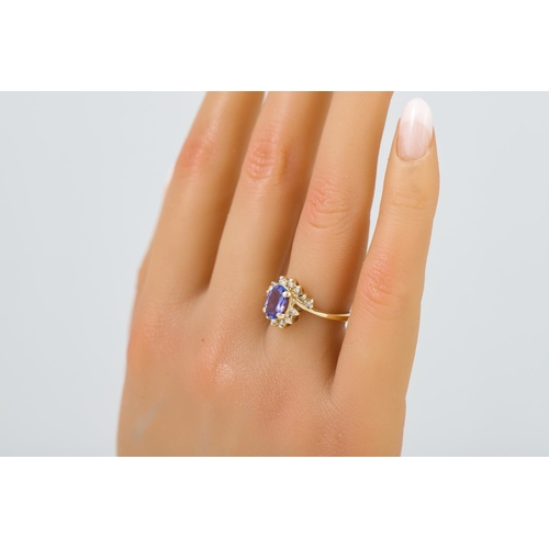 470 - A TANZANITE AND DIAMOND CLUSTER RING, mounted in 14ct gold. Size L - M