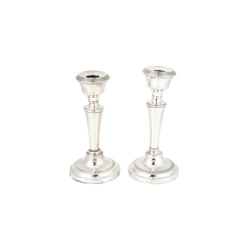 538 - A MATCHING PAIR OF STERLING SILVER CANDLE STICKS, raised over stepped circular base, together wiht a... 