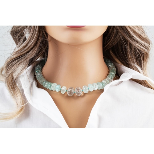 56 - AN AQUAMARINE BEADED NECKLACE, the carved beads to an 18ct gold diamond set barrel clasp