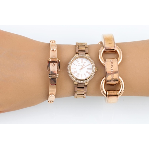 86 - A MICHAEL KORS WATCH, together with two bangles in a pouch