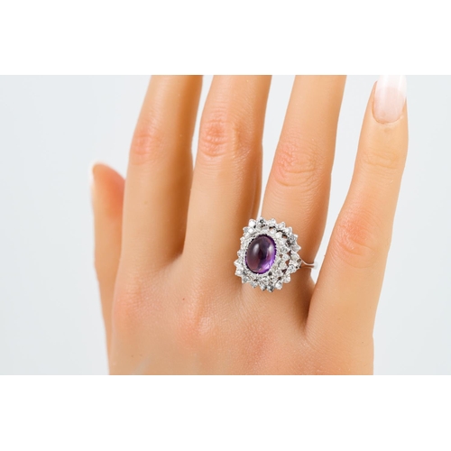 87 - AN AMETHYST AND DIAMOND CLUSTER RING, the cabochon amethyst to a two tiered diamond surround.  Estim... 