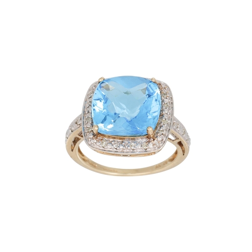 103 - A DIAMOND AND TOPAZ DRESS RING, the mixed cut topaz to diamond surround and shoulders, mounted in ye... 