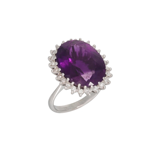 109 - AN AMETHYST AND DIAMOND CLUSTER RING, the large oval amethyst to diamond surround, mounted in 18ct w... 