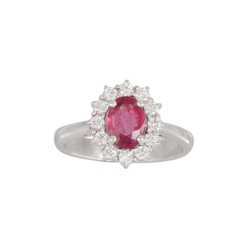 198 - A RUBY AND DIAMOND CLUSTER RING, the oval ruby to round brilliant cut diamond surround, mounted in 1... 