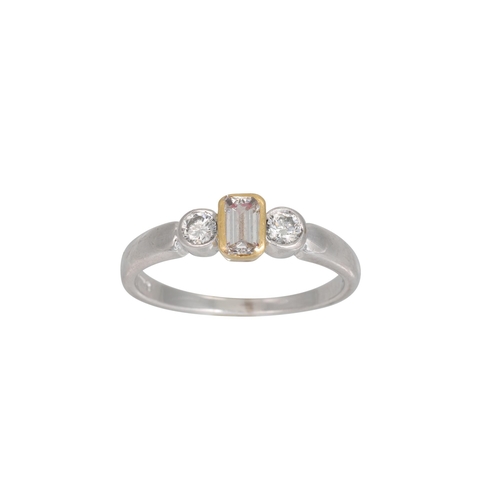 264 - A THREE STONE DIAMOND RING, the emerald cut stone to brilliant cut shoulders, mounted in white and y... 