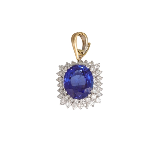 289 - A TANZANITE AND DIAMOND CLUSTER PENDANT, the oval tanzanite to two rowed brilliant cut diamond surro... 