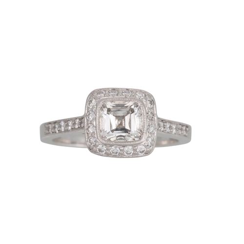 338 - A TIFFANY DIAMOND CLUSTER RING, the cushion cut diamond to a brilliant cut diamond surround and shou... 