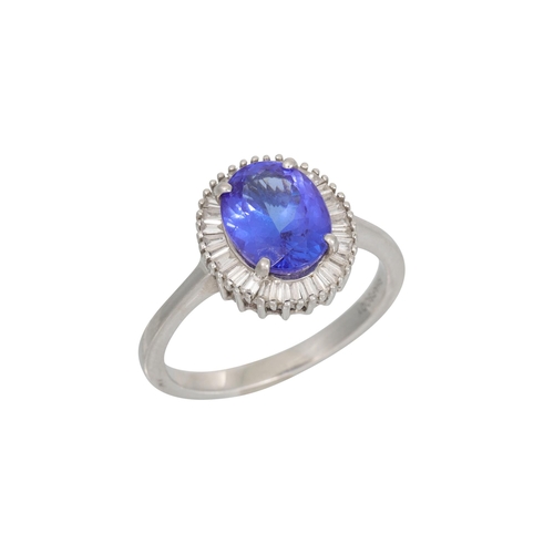 356 - A TANZANITE AND DIAMOND CLUSTER RING, the oval tanzanite to baguette diamond surround, mounted in pl... 