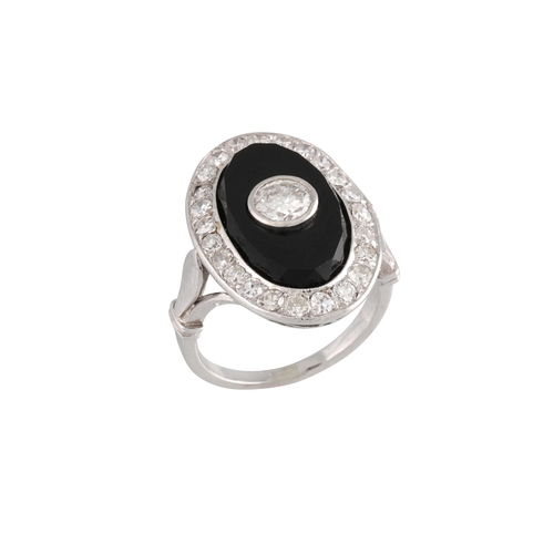 409 - AN ONYX AND DIAMOND PLAQUE RING, the old cut diamond within an onyx plaque to a diamond surround. Fr... 