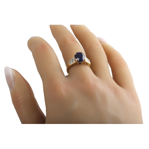 410 - A SAPPHIRE SINGLE STONE RING, the oval sapphire to baguette shoulders. French assay mark for 18ct go... 