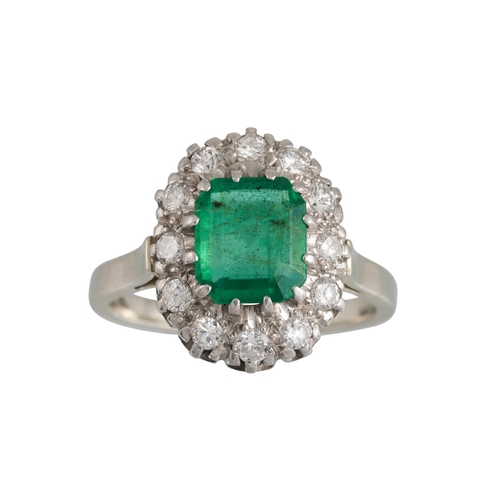 414 - A VINTAGE EMERALD AND DIAMOND CLUSTER RING, the rectangular emerald to a brilliant cut diamond surro... 