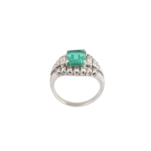 459 - AN EMERALD AND DIAMOND CLUSTER RING, the octagonal emerald to a brilliant and baguette diamond surro... 