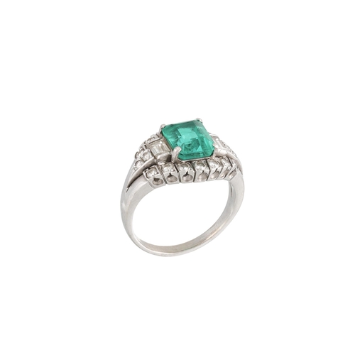 459 - AN EMERALD AND DIAMOND CLUSTER RING, the octagonal emerald to a brilliant and baguette diamond surro... 