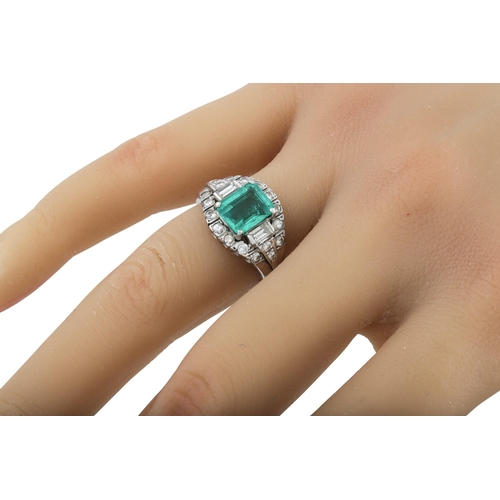 459 - AN EMERALD AND DIAMOND CLUSTER RING, the octagonal emerald to a brilliant and baguette diamond surro... 