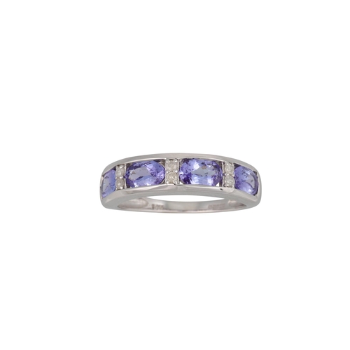 76 - A FOUR STONE TANZANITE AND DIAMOND RING, the oval-shaped tanzanite to diamond dividers, mounted in 1... 