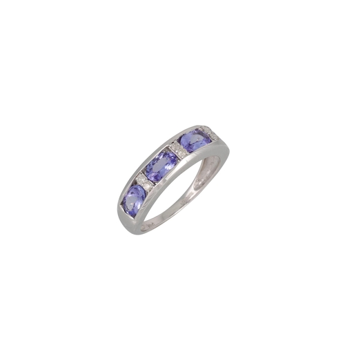 76 - A FOUR STONE TANZANITE AND DIAMOND RING, the oval-shaped tanzanite to diamond dividers, mounted in 1... 