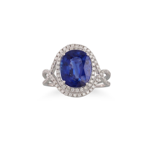 268 - A SAPPHIRE AND DIAMOND CLUSTER RING, the oval sapphire to diamond surround, split diamond shoulders,... 