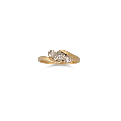 62 - A THREE STONE DIAMOND RING, mounted in yellow gold, cross-over setting. Estimated: weight of diamond... 