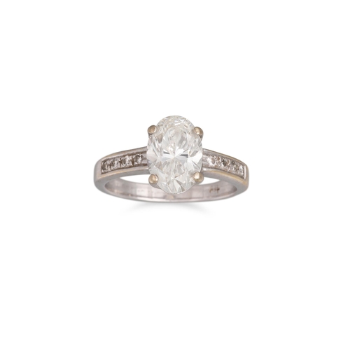 373 - A DIAMOND SOLITAIRE RING, the oval diamond to round brilliant cut diamond shoulders, mounted in 18ct... 