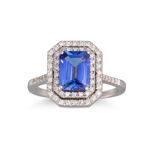 253 - A TANZANITE AND DIAMOND RING, the rectangular tanzanite to a two rowed diamond surround and shoulder... 