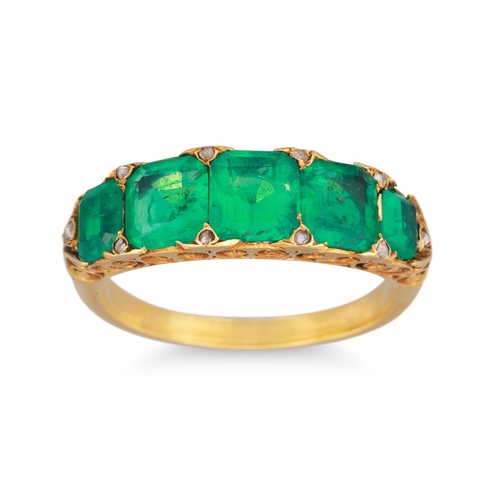 281 - A FIVE STONE EMERALD RING, set with graduated trap cut emeralds to a carved yellow gold mount, set w... 