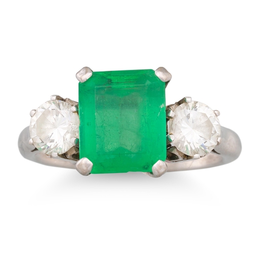 228 - AN EMERALD AND DIAMOND THREE STONE RING, the rectangular emerald to brilliant cut diamonds, mounted ... 