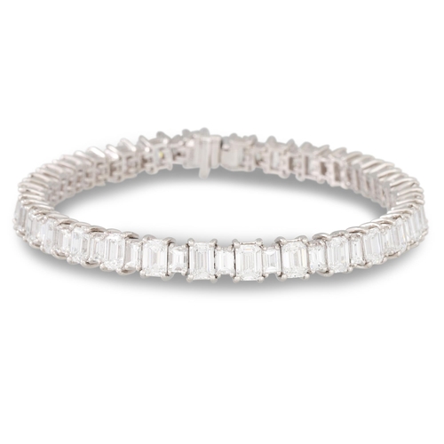 242 - A DIAMOND LINE BRACELET, the emerald cut diamonds mounted in 18ct white gold. Estimated: weight of d... 