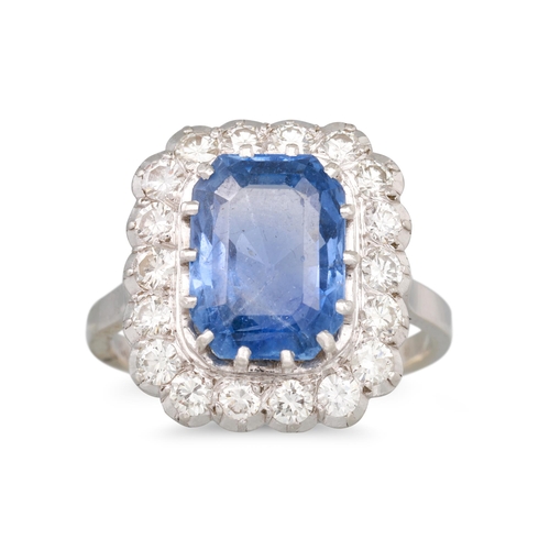 268 - A SAPPHIRE AND DIAMOND CLUSTER RING, the rectangular sapphire to a brilliant cut diamond surround, m... 