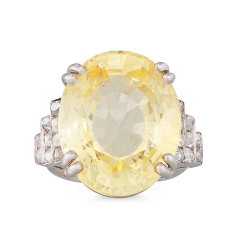 290 - AN EARLY 20TH CENTURY YELLOW SAPPHIRE AND DIAMOND RING, the oval sapphire to stepped diamond shoulde... 