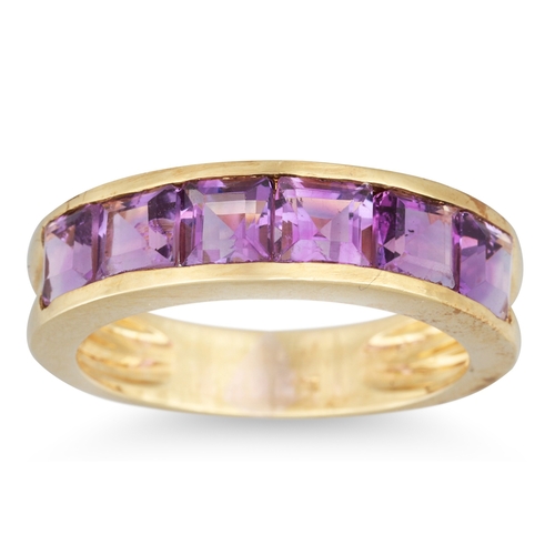 14 - AN AMETHYST BAND RING, the six channel set French cut amethysts mounted in yellow gold, size K