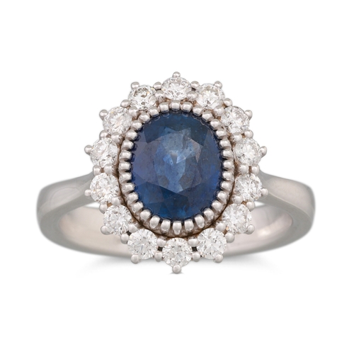 250 - A SAPPHIRE AND DIAMOND RING, the oval sapphire to diamond surround, mounted in 18ct white gold. Esti... 