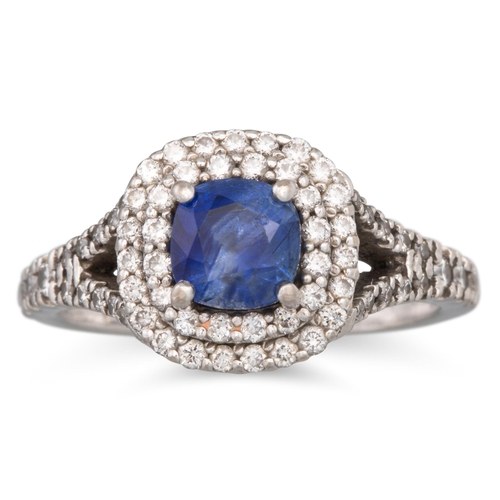 227 - A SAPPHIRE AND DIAMOND CLUSTER RING, the cushion cut sapphire to double row of brilliant cut diamond... 