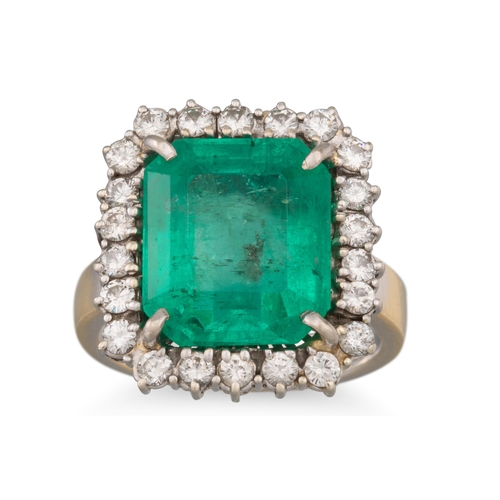 229 - AN EMERALD AND DIAMOND CLUSTER RING, the trap cut emerald to brilliant cut diamond surround, mounted... 