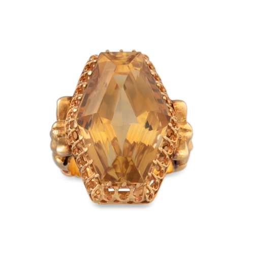 207 - A CITRINE RING, the large hexagonal shaped ring to a carved yellow gold mount depicting female forms... 