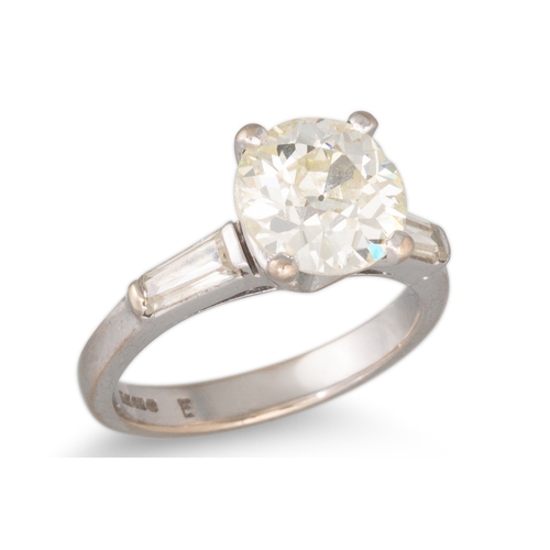 352 - A DIAMOND SOLITAIRE RING, the old cut diamond to tapered baguette diamond shoulders, mounted in whit... 