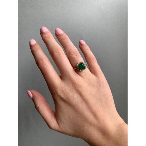 252 - A DIAMOND AND EMERALD CLUSTER RING, the square trap cut emerald to brilliant cut diamond surround an... 